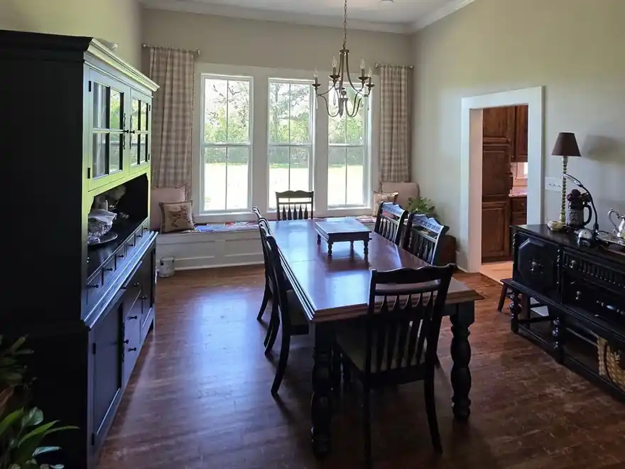 Dining room with a black hutch against greige walls and white trim