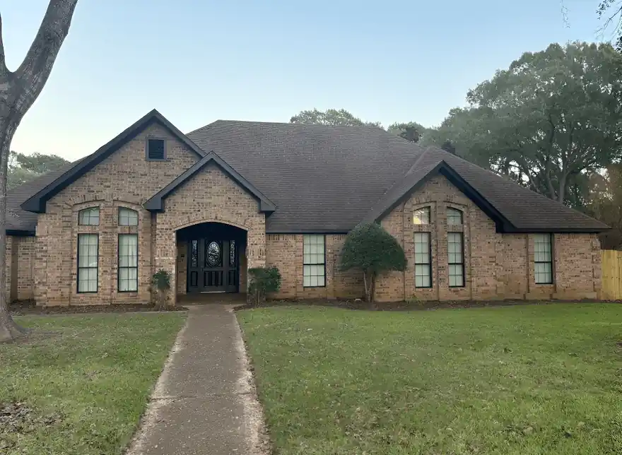 Brick house with fresh painted trim and a front lawn