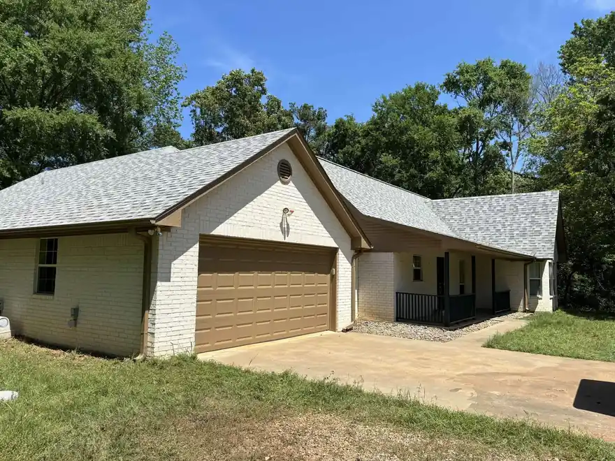 White painted brick house with a wood garage door and a fresh trim line