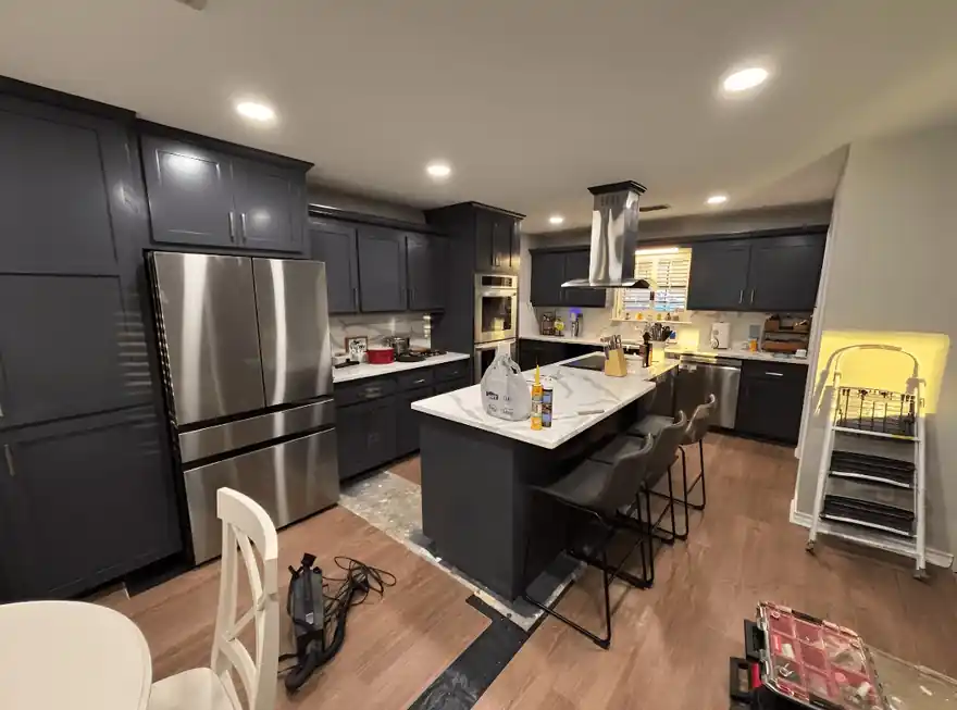 Kitchen with black painted cabinets and a white island