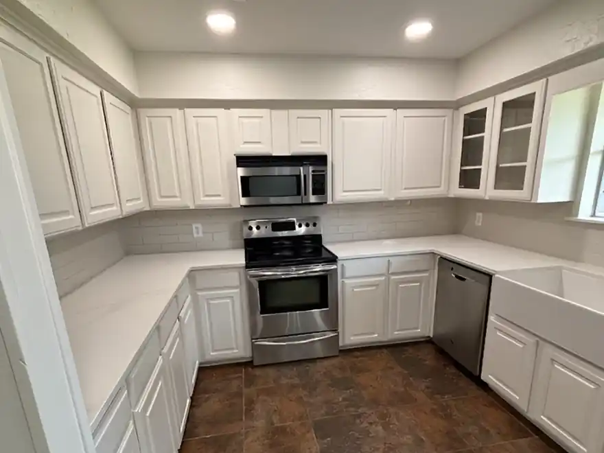 White painted shaker kitchen cabinets with a stainless range