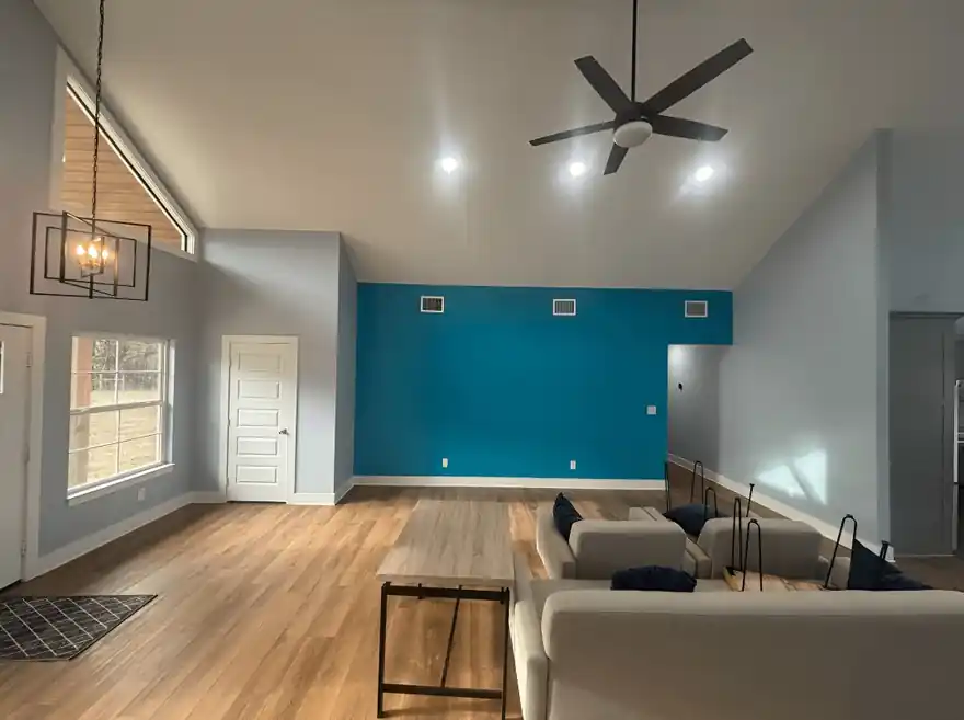 Open living room with a bright teal accent wall