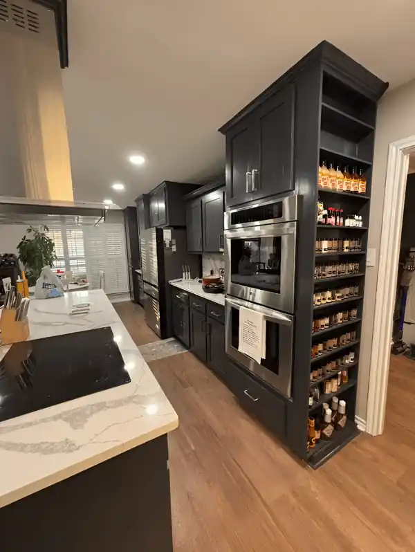 Black built-in pantry and wine cabinets with a quartz counter