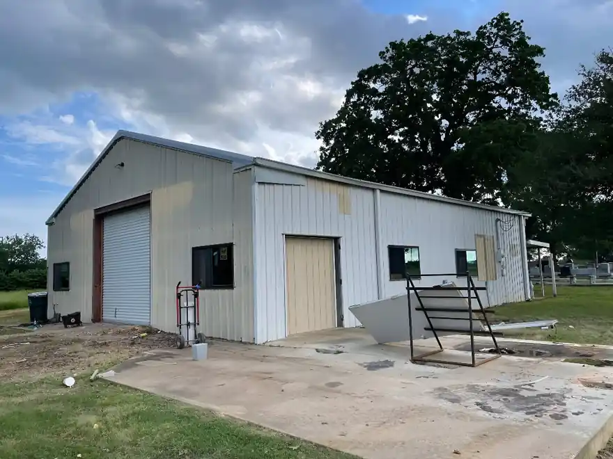 White painted metal shop building with roll-up doors